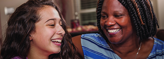 Volunteer laughing with child.